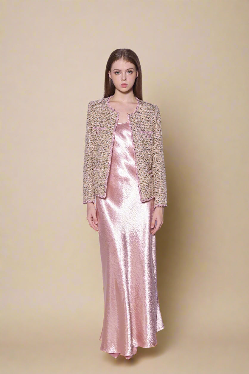 Woman wearing a pink satin dress and beige pink chanel jacket 