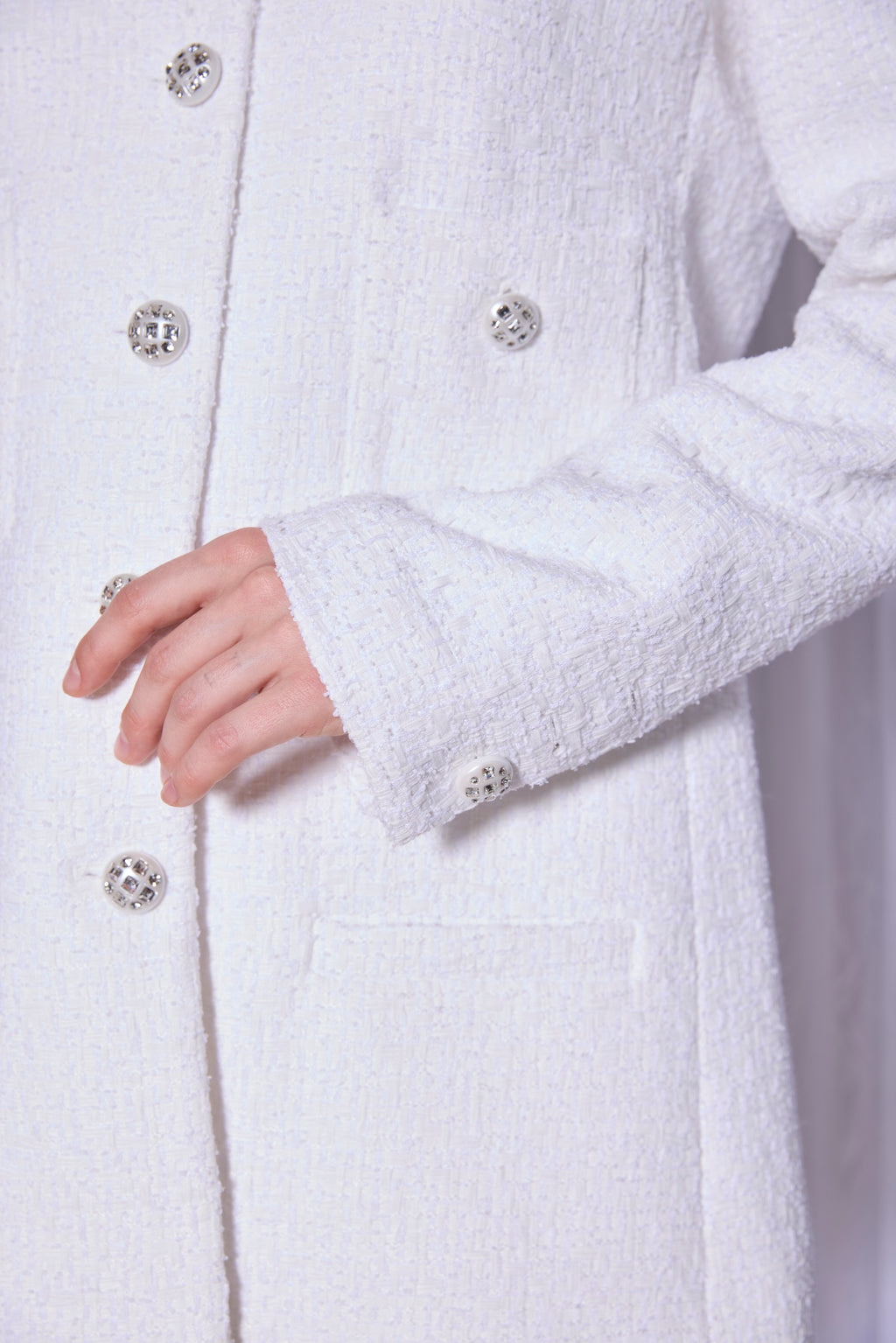 Close-up of a white coat with button details