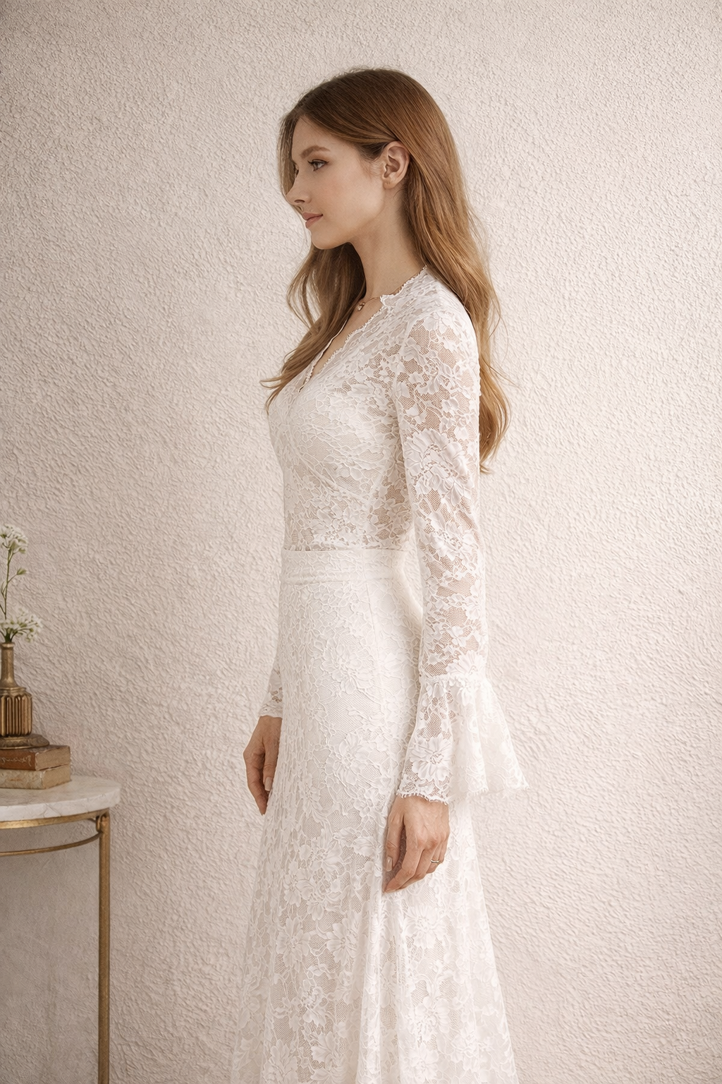 Woman wearing a white lace dress against a plain background
